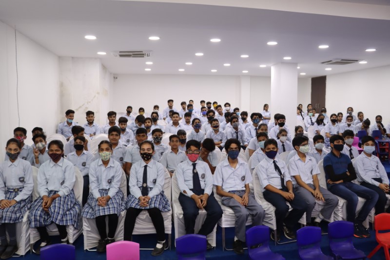 A teacher leading a values-based discussion in a classroom, with students attentively participating at Greater Noida World School.
